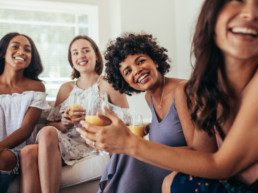 Image of happy people laughing and sharing cocktails